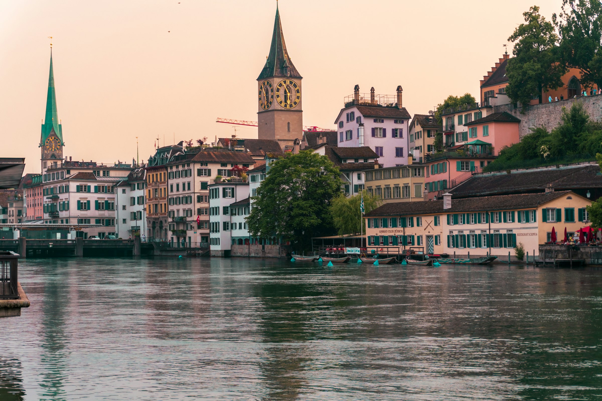 Zürich along the Limmat at dusk, with St. Peter and the historic riverfront